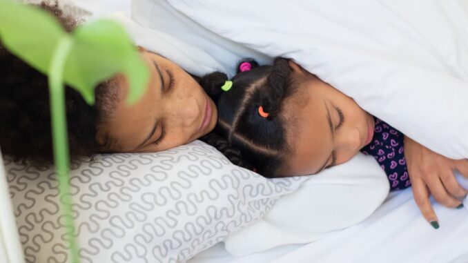 Rest Well Bundle: Mutter und Tochter schlafen friedlich zusammen im Bett