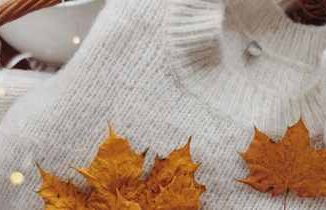 Gemütlicher Herbst-Look mit Wollpullover und Ahornblättern als Symbol für Healy im Herbst