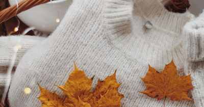 Gemütlicher Herbst-Look mit Wollpullover und Ahornblättern als Symbol für Healy im Herbst